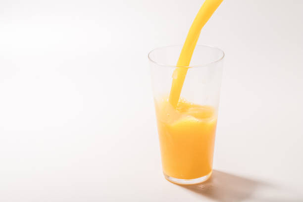 Orange juice pouring into a cup