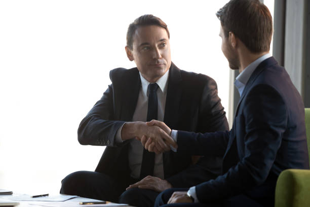 istock Businessmen handshake signing contract closing successful deal 1173338357