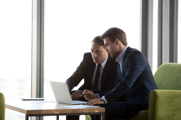 istock Focused business partners negotiate working on laptop 1173338367