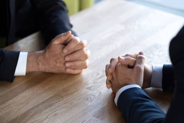istock Close up of businessmen sit with hands clenched making decision 1173338410