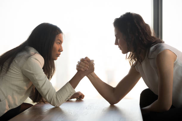 istock Strong women arm wrestle at work struggle for leadership 1173338428