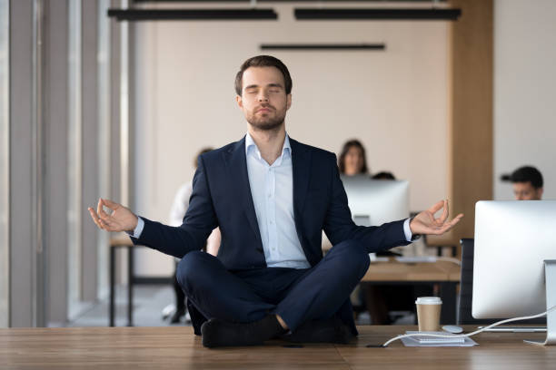 istock Peaceful businessman meditating with eyes closed at workplace 1173338471