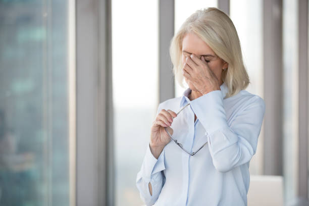 istock Tired mature woman take off glasses suffering from headache 1173338517