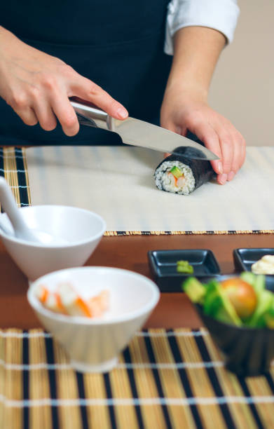 istock Female chef cutting japanese sushi roll 1173338837