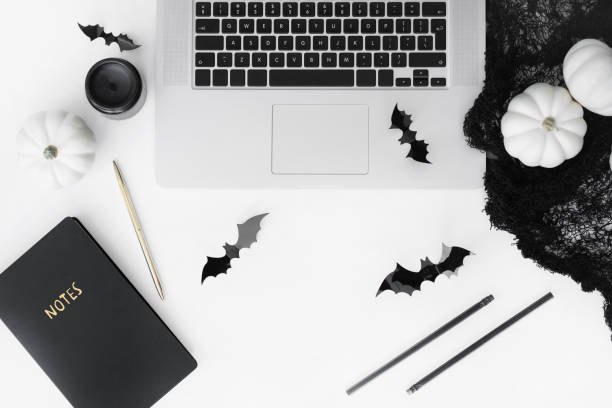istock Halloween styled flat lay with laptop and decorative accessories top view on white table. 1173339003