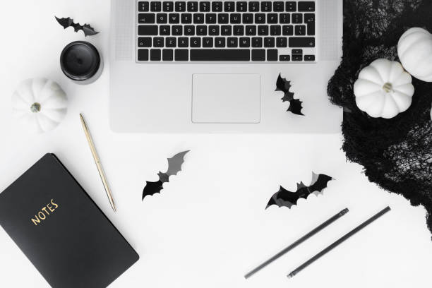 Halloween styled flat lay with laptop and decorative accessories top view on white table. Halloween styled flat lay on white table katt halloween stock pictures, royalty-free photos & images