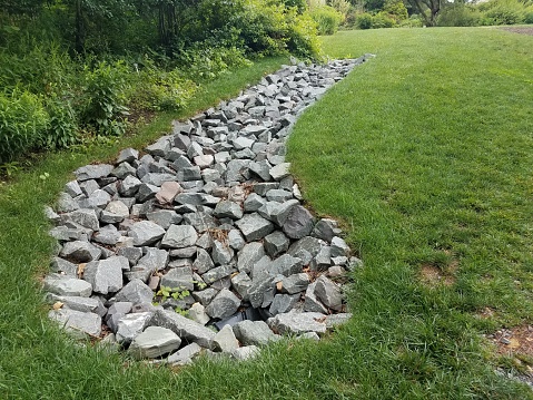 green grass lawn or yard with large grey rocks