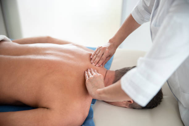 istock Female medic is doing shoulder massage fot man 1173342145
