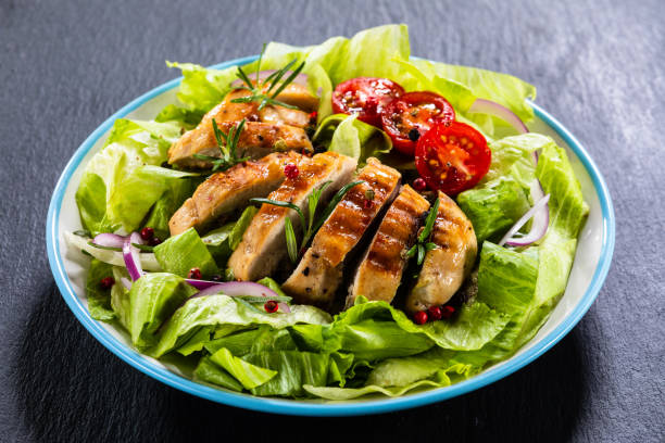 caesar salad  - vegetable salad with roast chicken meat on black stone - side salad imagens e fotografias de stock