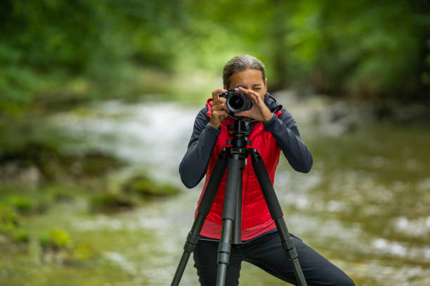 istock female photographer behind camera outdoors in river 1173344400