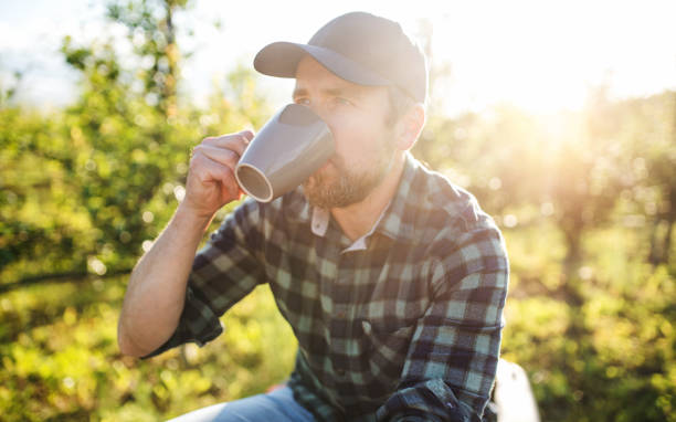 istock A mature farmer with cup of coffee outdoors in orchard, resting. 1173345902