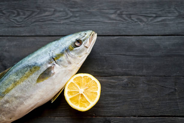 istock Fresh tuna and lemon on a wooden black background, top view with copy space. 1173347522