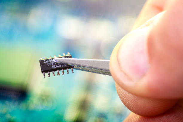 electronics hand engineer assembles the chip - close up small circuit board computer chip imagens e fotografias de stock