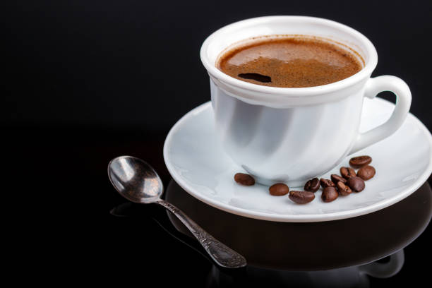 istock Cup of coffee on a black glass table 1173351219