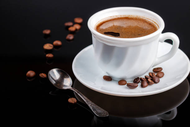 istock Cup of coffee on a black glass table 1173351245