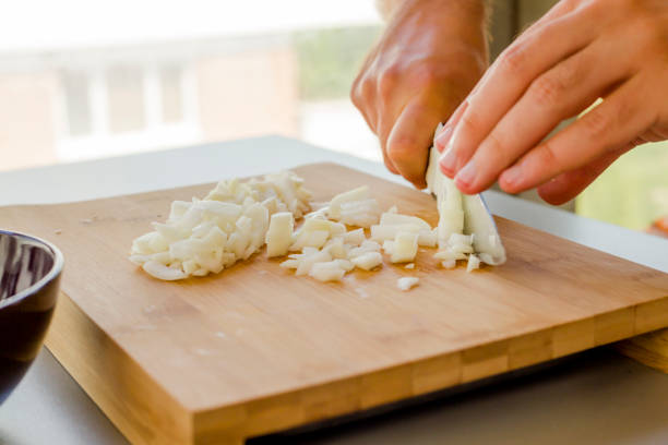 istock Hands chopping onion in wooden board 1173351319