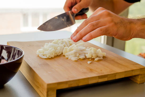 istock Hands chopping onion in wooden board 1173351338