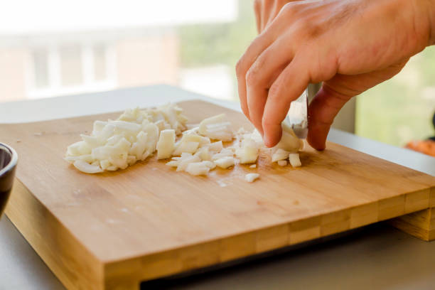 istock Hands chopping onion in wooden board 1173351341