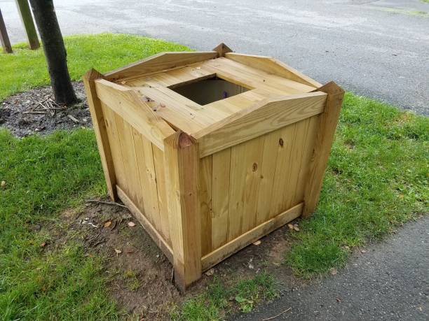 istock brown wood garbage can wih square hole with black asphalt 1173351837