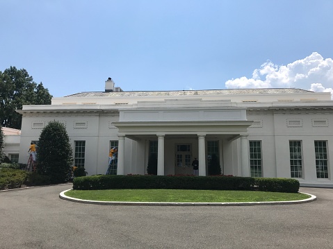 Washington DC USA,Aug 01 2019:Oval office cleaning outer wall.A cleaning worker wearing yellow clothes is manually cleaning.