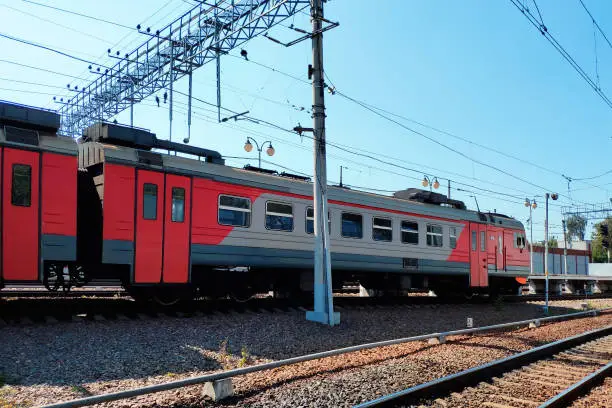 Photo of Red suburban train on the station close up. Railway platform with train.