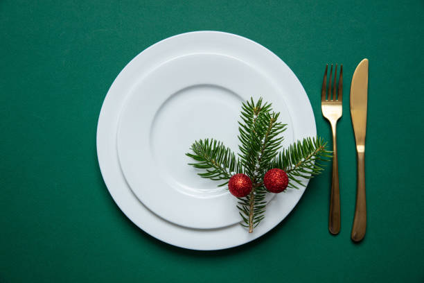 istock Fir tree twig on white set of dishes isolated, green background 1173357170