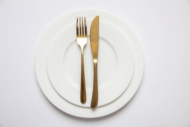 ajuste de mesa, formal. cuchillería de oro sobre conjunto blanco de platos, fondo blanco - nobody table knife food dinner fotografías e imágenes de stock