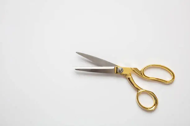 Scissors open gold and silver color isolated against white background, copy space, top view. Tailor, barber concept