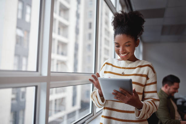 istock Smiling Brazilian female executive using a digital tablet in a modern architectural setting set in South America 1173361692