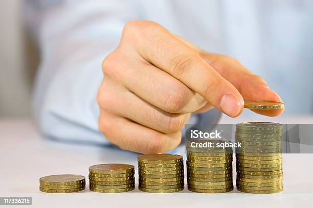 Coins Gradually Increasing In Size Being Placed By A Man Stock Photo - Download Image Now