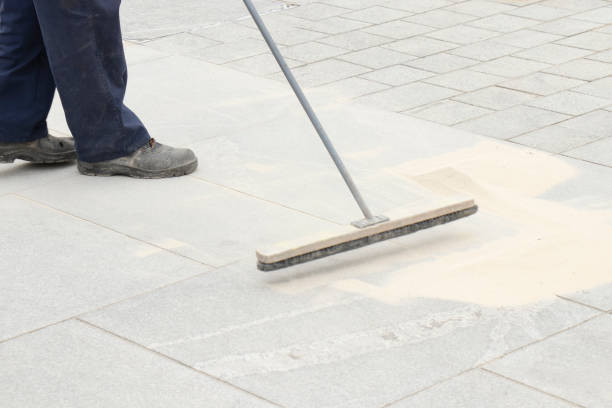 istock Pavement construction worker filling the block joints with sand using long broom 1173362343