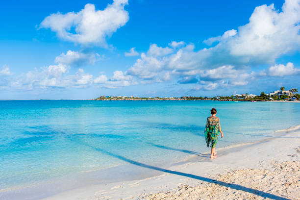 Turks and Caicos, Providenciales - woman walking on the beach at Sapodilla Bay Turks & Caicos turks and caicos islands caicos islands bahamas island stock pictures, royalty-free photos & images