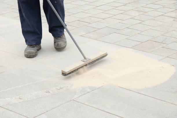 istock Pavement construction worker filling the block joints with sand using long broom 1173362926