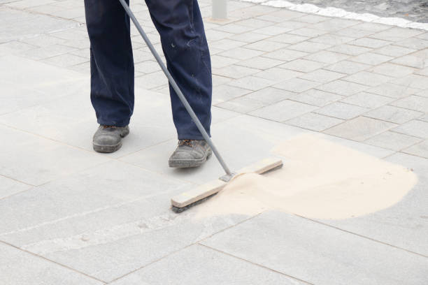 istock Pavement construction worker filling the block joints with sand using long broom 1173363036