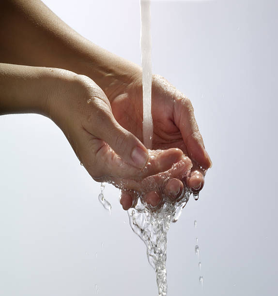 Water pouring into hand stock photo