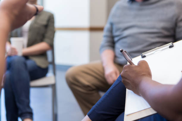 istock Mental health professional takes notes during support meeting 1173363245