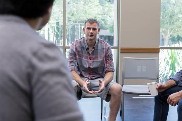 istock Mid adult veteran gestures while sharing during support group meeting 1173363328