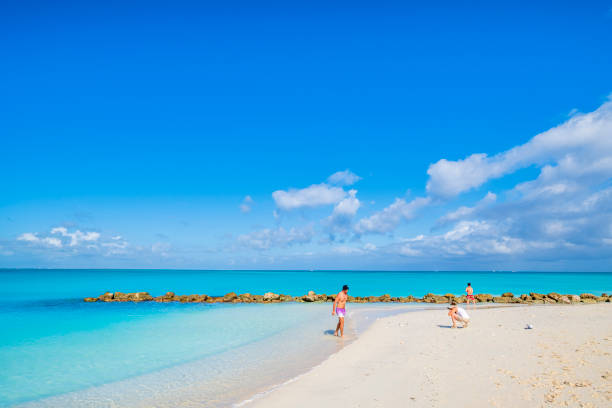 Turks and Caicos, Providenciales - Grace Bay Beach Tourists on Grace Bay Beach, rated among the most beautiful and pristine beaches in the world, located on the northeast coast of Providenciales, in the Turks and Caicos Islands. grace bay stock pictures, royalty-free photos & images