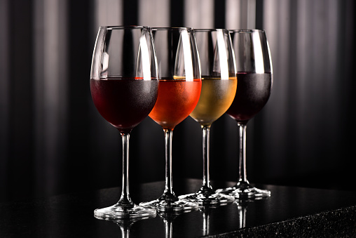 Four wine cups on bar table - dark background
