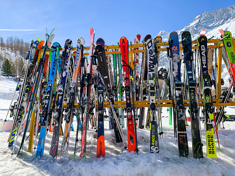 Skis and ski poles put in rack at slope of ski resort Cervinia, Italy.