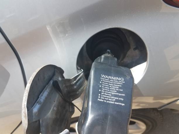 istock gas pump nozzle in a gas tank with warning text 1173372933
