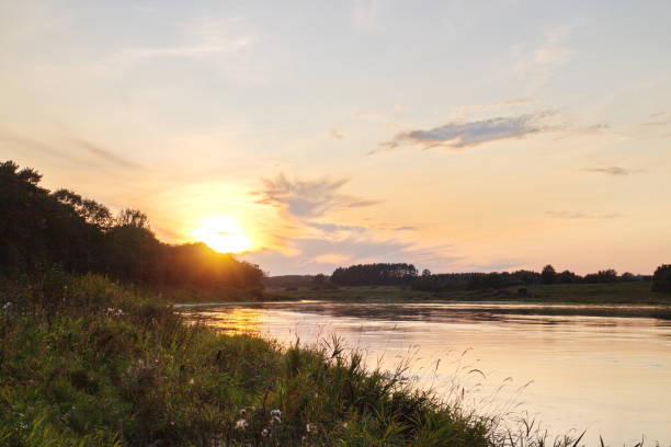 istock Sunset by the river in the summer countryside 1173378709
