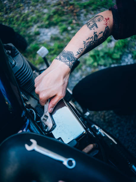 redhair женщина фиксации ее велосипед - motorcycle women tattoo sensuality стоковые фото и изоб�ражения