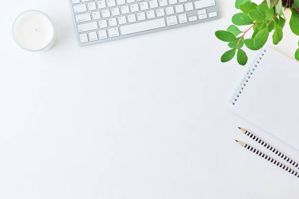 istock Blogger or freelancer workspace with keyboard, notebook and branches with green leaves on light background 1173381999