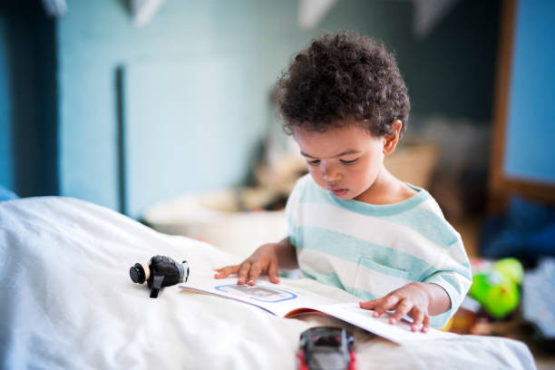 Cute little boy reading book at home
