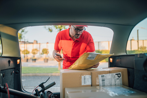 Delivery gay looking for right package in pick up track.