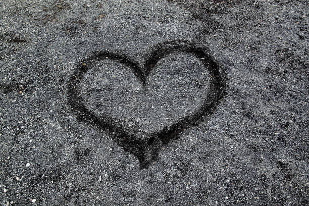 istock Heart shape drawn on a black sand beach 1173387634