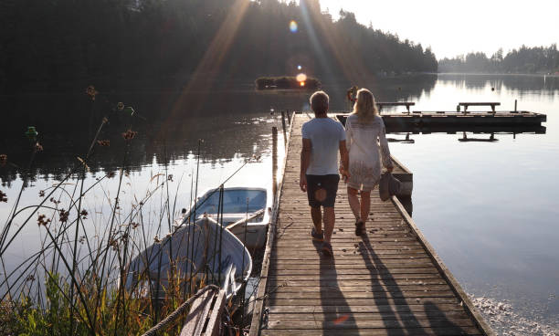 istock Couple walk along lakeside pier at sunrise 1173388478