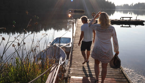 istock Couple walk along lakeside pier at sunrise 1173388510