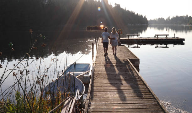 istock Couple walk along lakeside pier at sunrise 1173388515